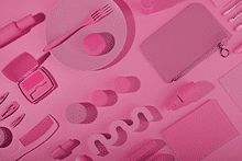 Elementos aleatorios de color rosa como un plato, una cartera, un peine, maquillaje, etc.